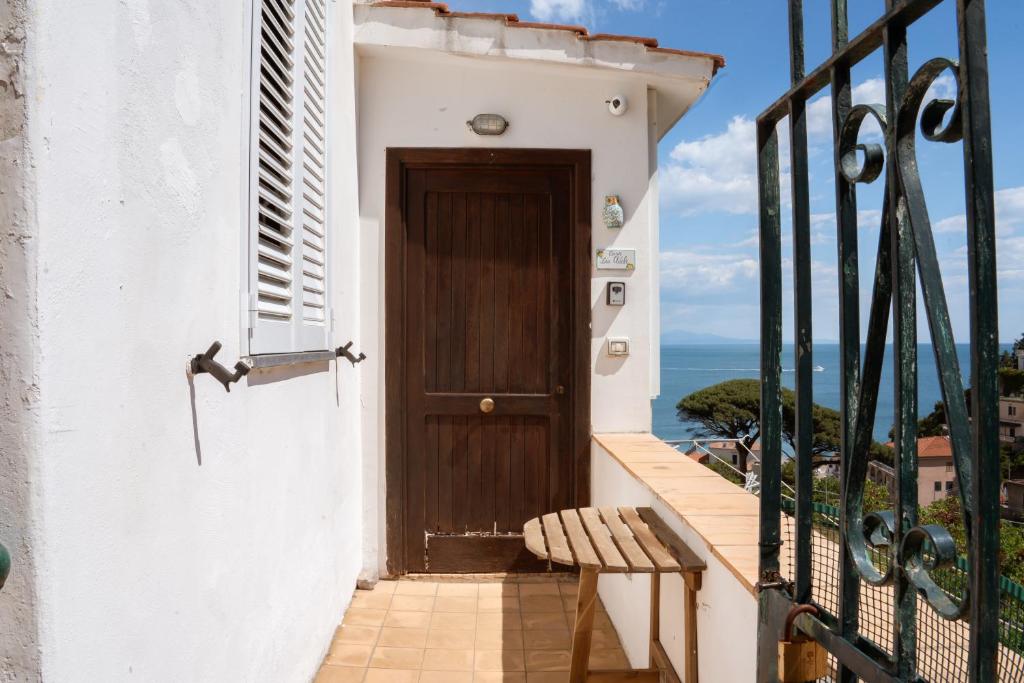 a wooden door on a balcony with a bench at Casa Zia Adele in Erchie