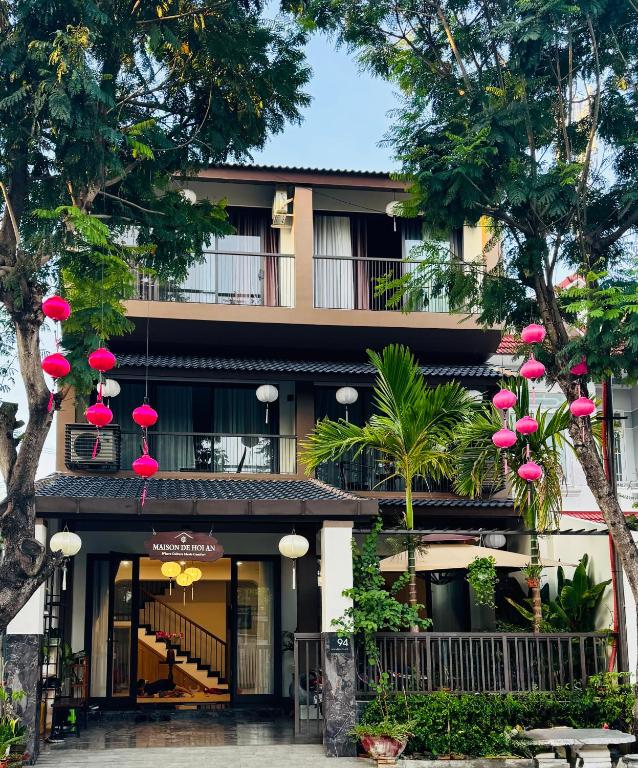 a building with pink paper lanterns in front of it at Maison De Hoi An Boutique Homestay in Hoi An