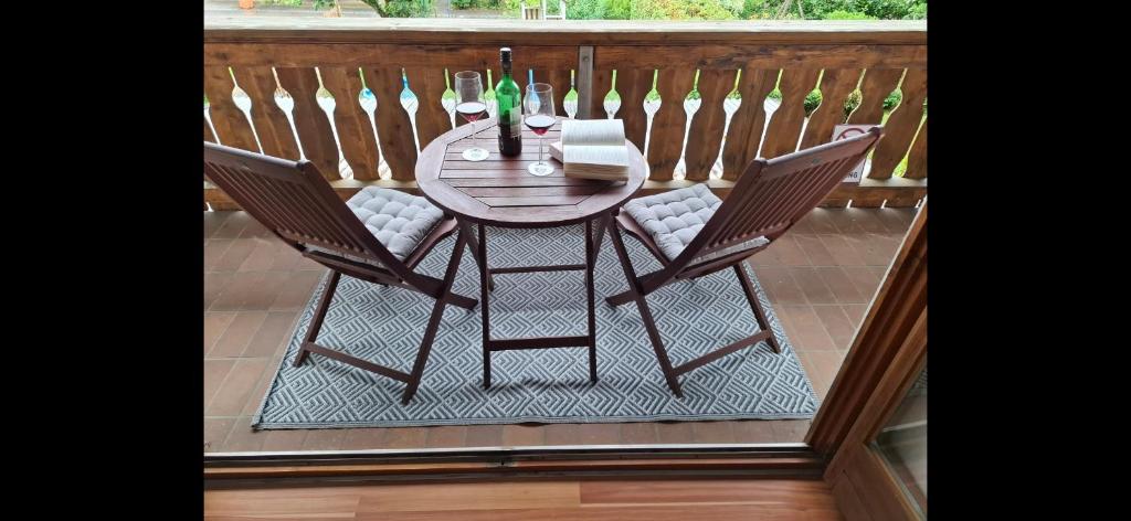 a wooden table and two chairs on a balcony at Ferienwohnung See und Sonne in Obing