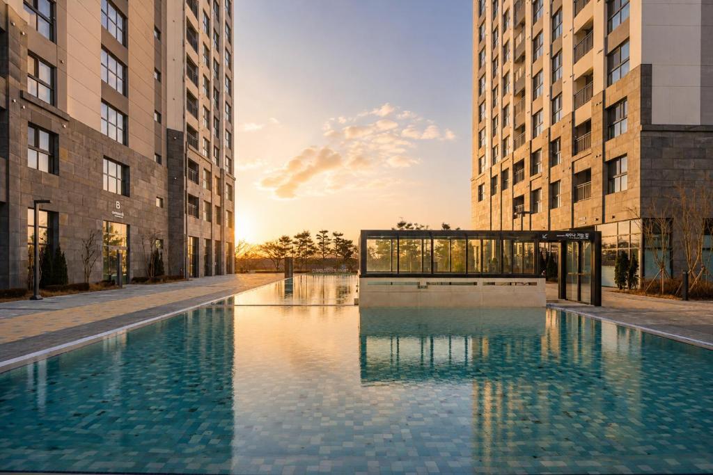 a swimming pool in the middle of two tall buildings at Le Collective Sokcho Central in Sokcho