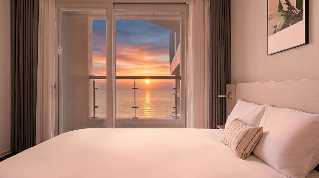 a bedroom with a window with a view of the ocean at Urbanstay Naksan Beach in Yangyang