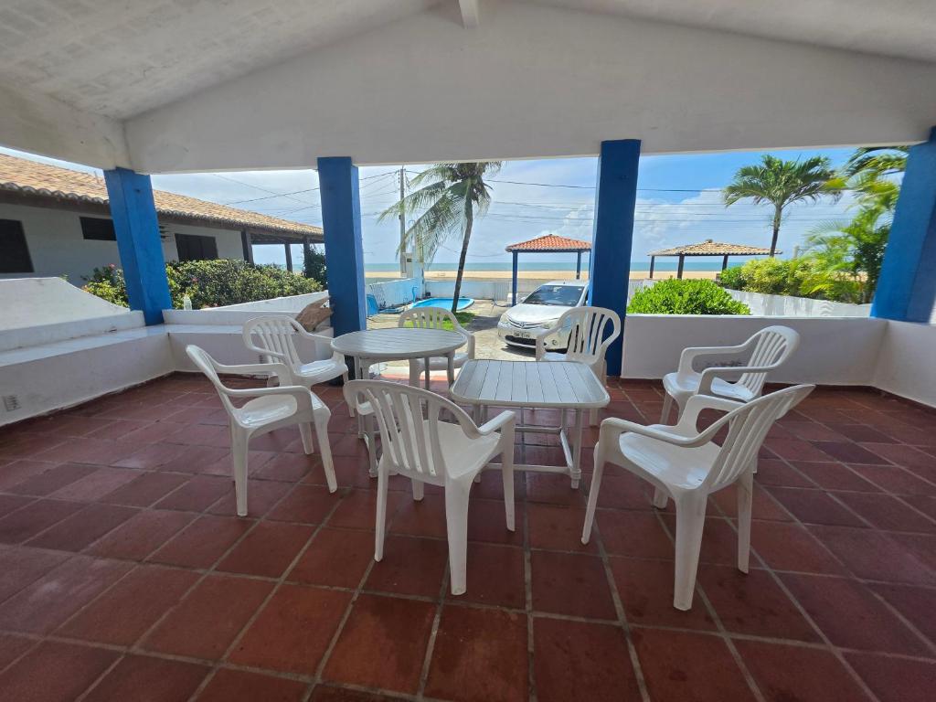 a patio with tables and chairs and a view of the ocean at PÉ NA AREIA EM Pirangi do Norte in Parnamirim