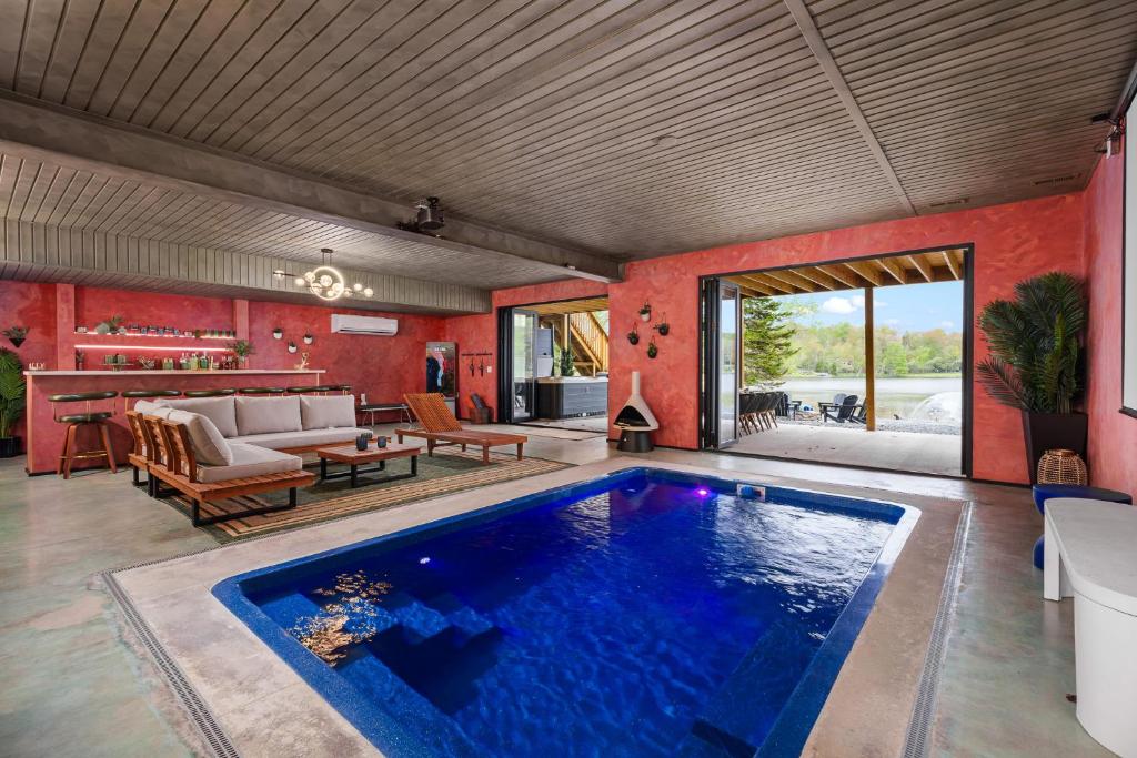 a swimming pool in a living room with red walls at The Four Seasons Escape in Pocono Lake