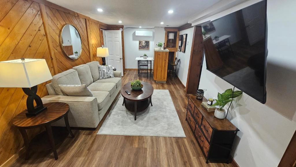 a living room with a couch and a table at Modern Two Bedroom Basement Apartment in Saint John