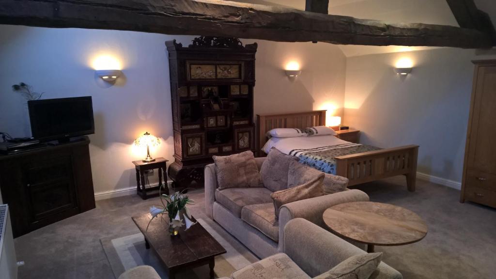 a living room with a bed and a couch at The Gate House Barn in Stanton in Peak