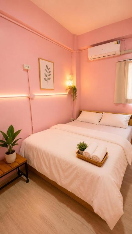 a bedroom with a large white bed in a room at Hostel In The City in Pom Prap