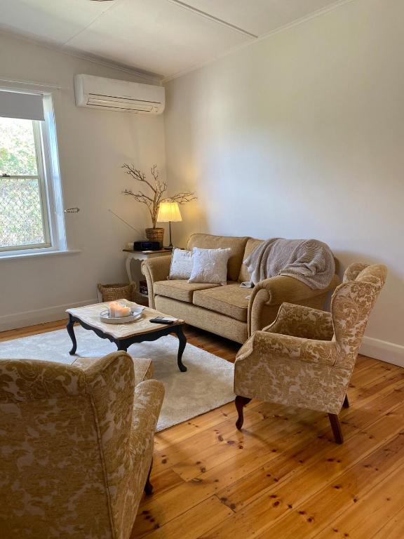 a living room with a couch and two chairs at Riverstone Cottage at Murray Bridge in Murray Bridge