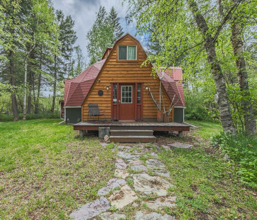 a cabin in the middle of a forest with a porch at Gateway to Glacier in Columbia Falls