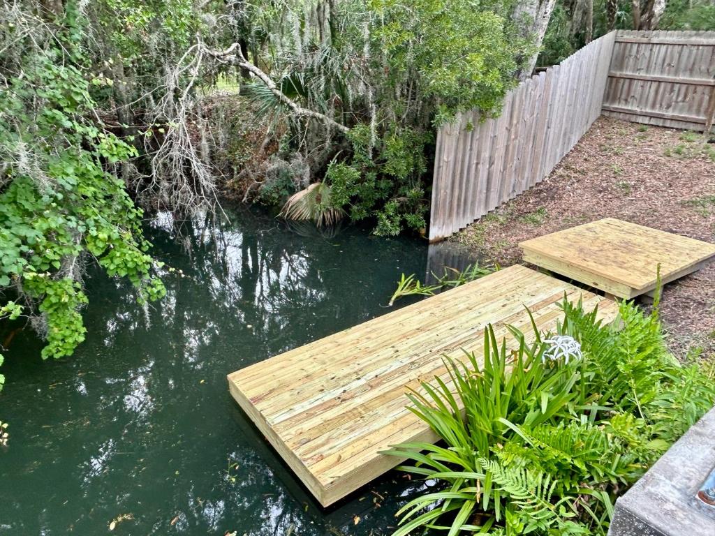 a wooden bridge over a pond in a garden at Natures Nest #2 in Homosassa
