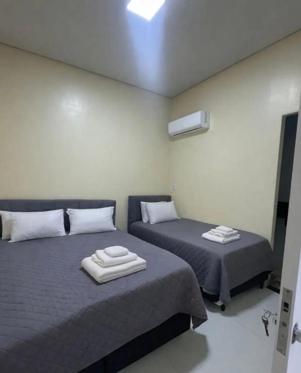 a bedroom with two beds with towels on them at Hospedagem Caripi in Barcarena