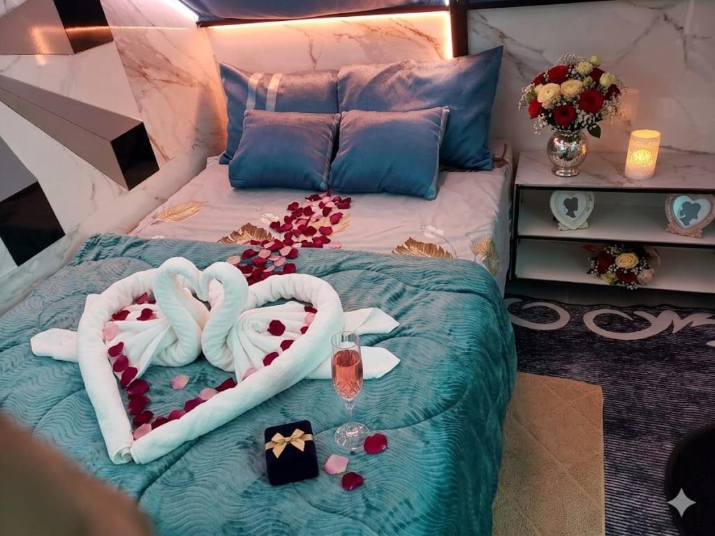 a bedroom with a bed with two heart shaped towels at Glamping La Escapadita in Baños