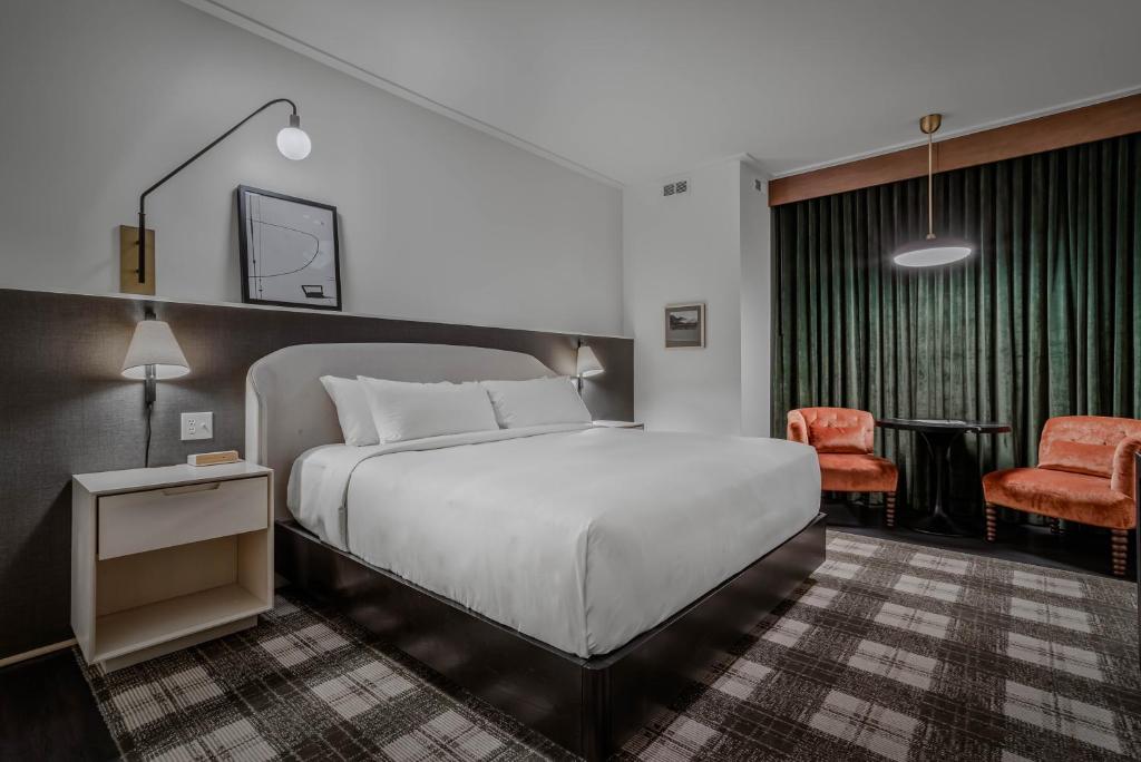 ein Hotelzimmer mit einem Bett und einem Stuhl in der Unterkunft Hotel Longmont in Longmont