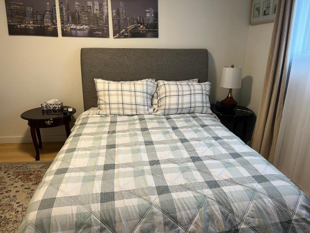 a bedroom with a bed with a plaid comforter at Cozy Escape in the City in Port Coquitlam