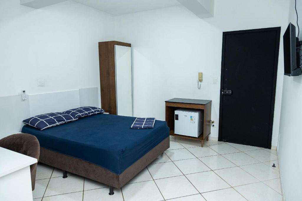 a bedroom with a bed and a mirror and a door at Loft Completo com Smart TV e Frigobar Compacto 08 in Presidente Prudente