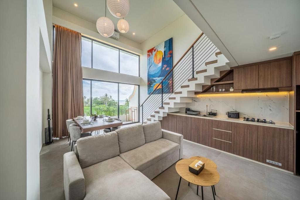 a living room with a couch and a staircase at Horizon Apartment with Ocean View in Cemagi