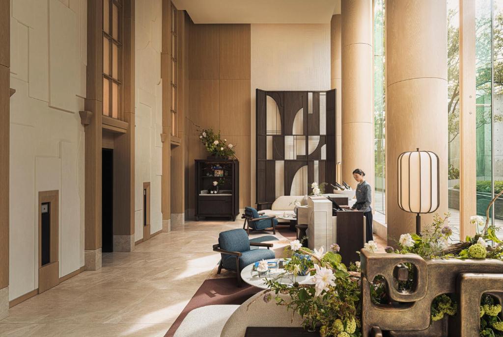 a lobby with a person sitting at a desk at Four Seasons Hotel Tokyo at Marunouchi in Tokyo