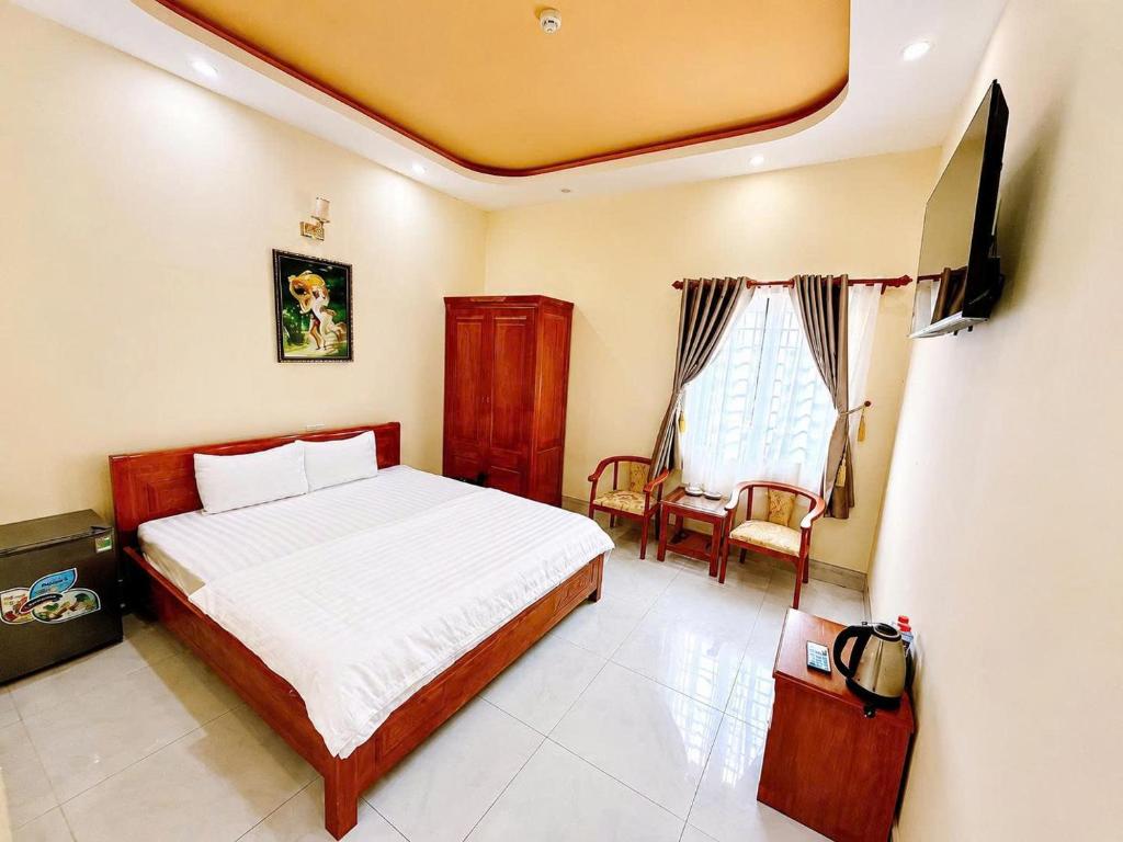 a bedroom with a bed and a chair at Cali Hotel Tây Ninh in Tây Ninh