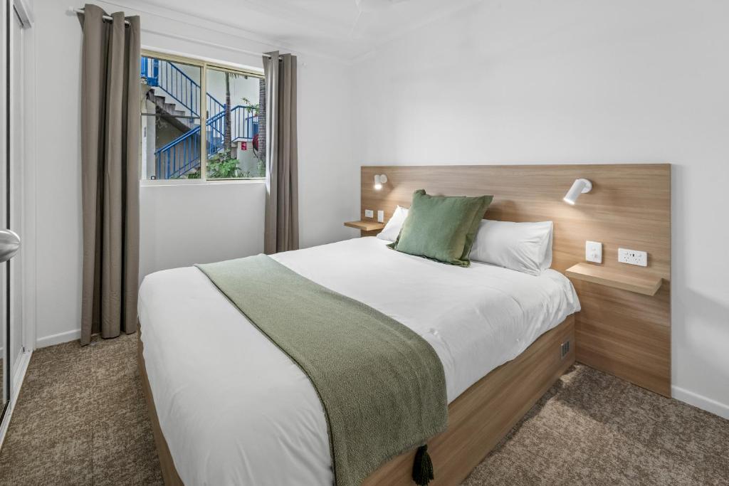 a bedroom with a large bed and a window at Mackay Seabreeze Apartments in Mackay