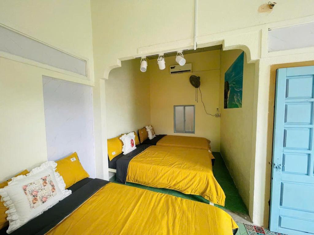 two beds in a room with yellow and black at Homestay Đại Nghĩa in Quảng Ngãi