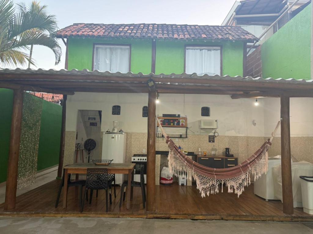 a patio with a table and a hammock in front of a house at Chalé Lunar in Arraial d'Ajuda