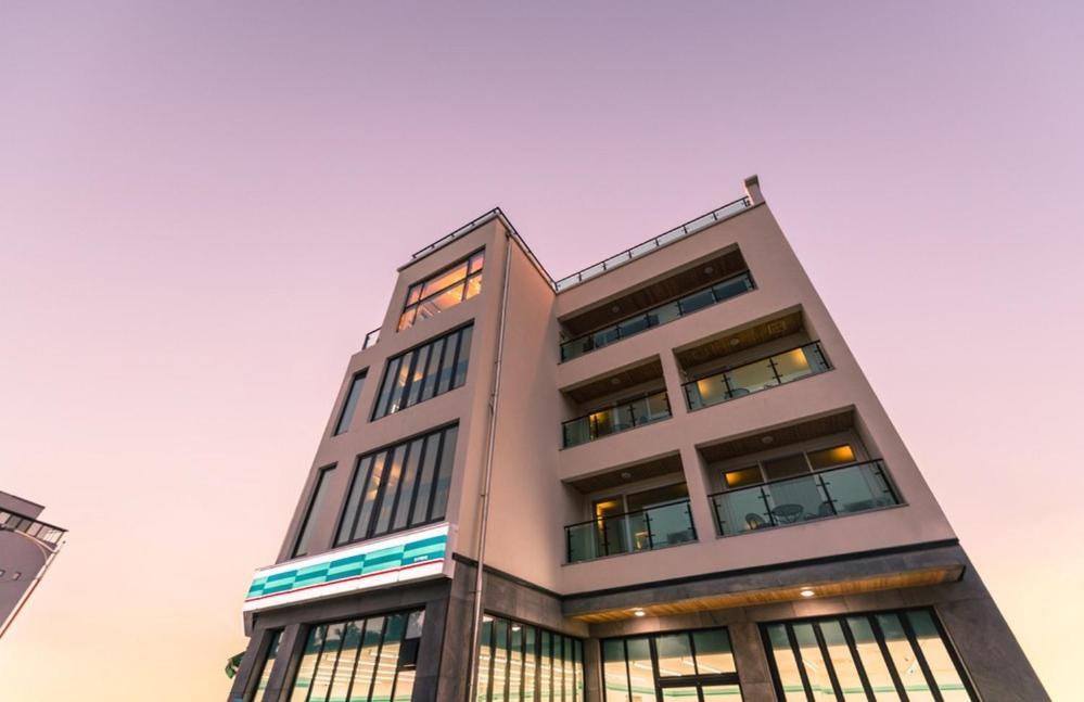 a tall white building with many windows at Yangyang Hotel Unbound House in Yangyang