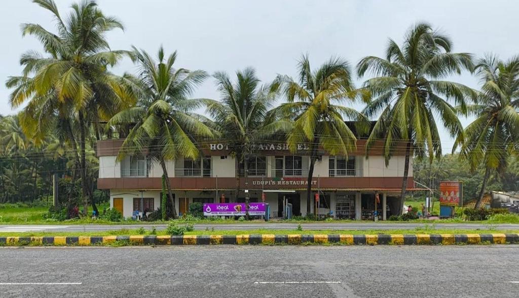 budynek z palmami przed nim w obiekcie Hotel Matashree w mieście Magdāl