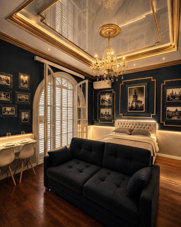 a bedroom with a bed and a couch and a chandelier at Salvo 1928 in Montevideo