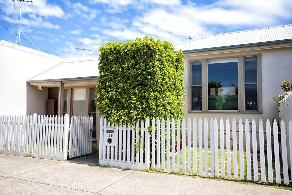 a white fence in front of a white house at Bella Casa in Queenscliff