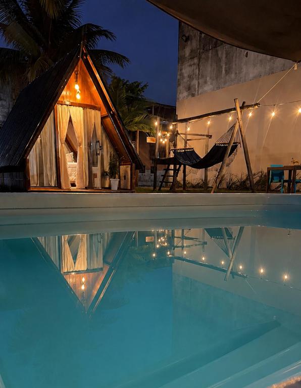 a night view of a house and a swimming pool at Chalé Selá - Recanto 23 - Espaço Inteiro - Entre Angra e Paraty in Angra dos Reis