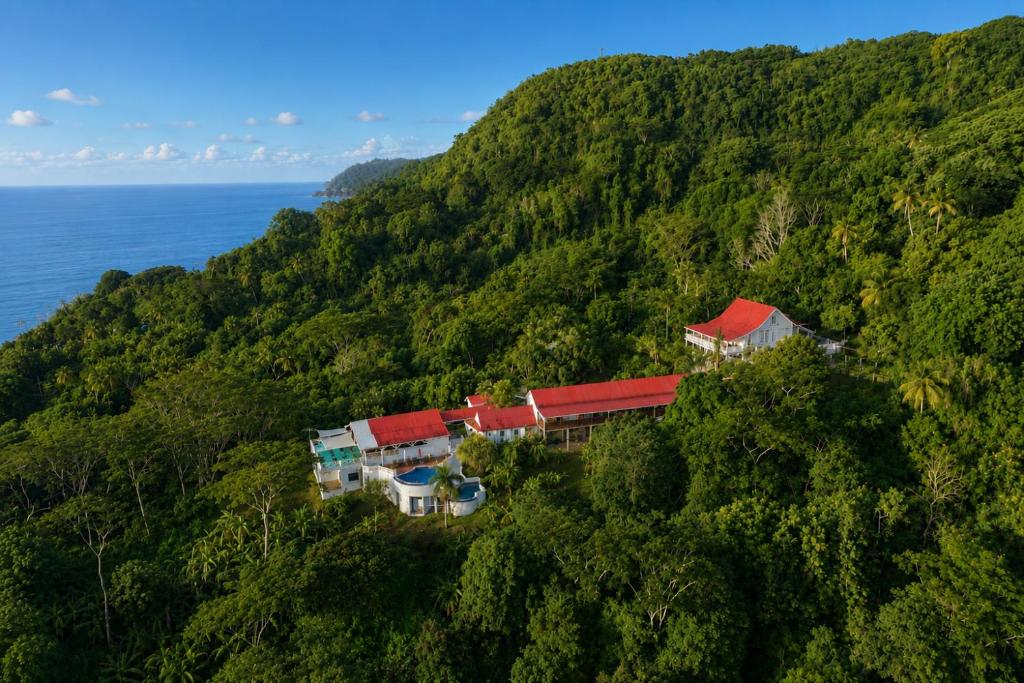 a house on top of a hill next to the ocean at Mount Edgecombe Boutique Hotel in Maran