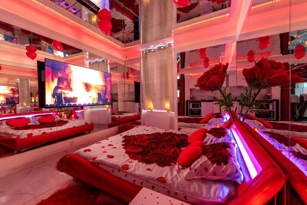 a bedroom with a bed with red roses on it at Le miroir secret in Gien