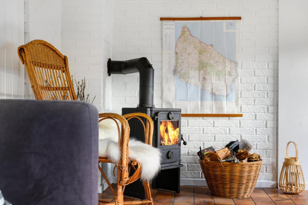 a living room with a wood stove and a chair at Cozy Holiday Home Close To Forest And Beach in Hasle