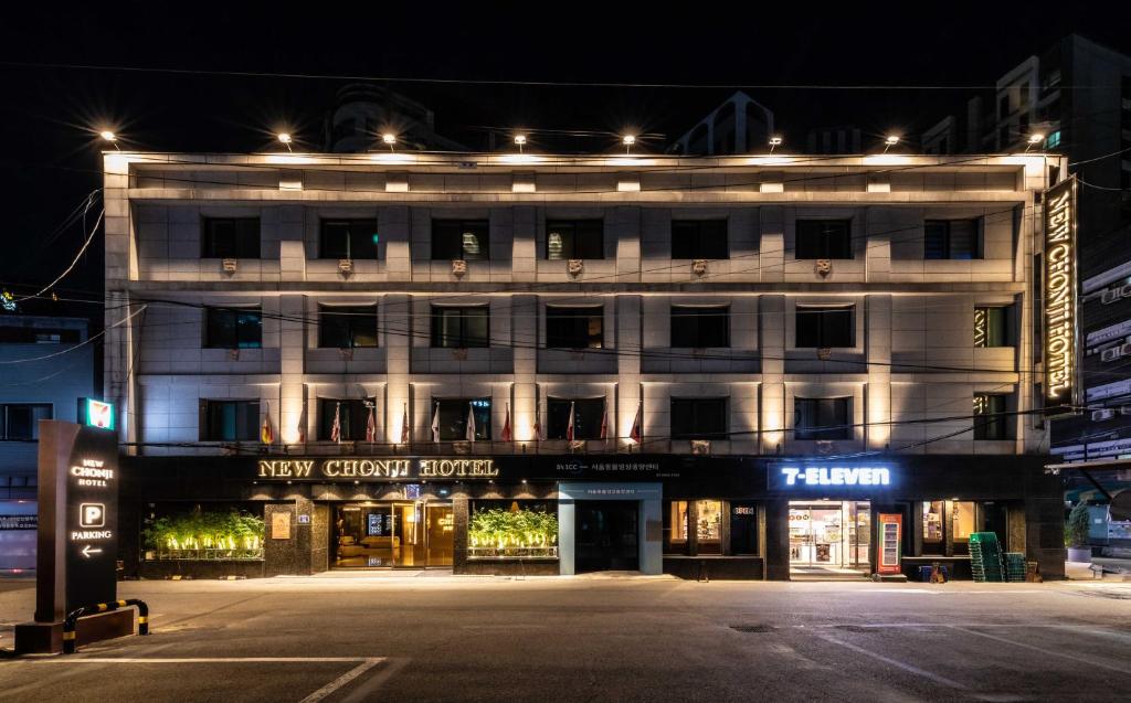 a lit up building on a street at night at New Cheonji Hotel in Seoul