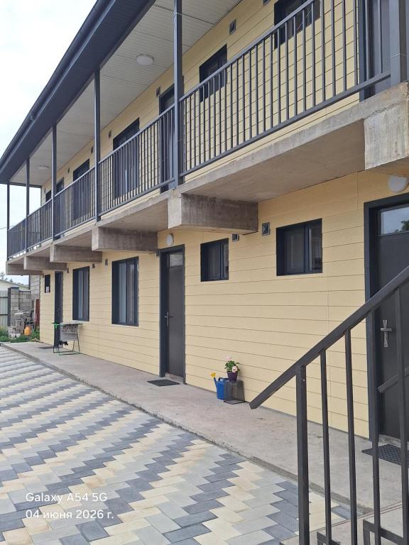 a yellow building with a balcony on the side of it at NovaMotel in Karakol