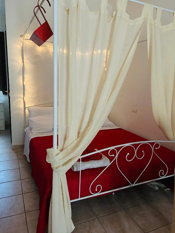 a bedroom with a canopy bed with a curtain at Casa Rossa in Ferentillo