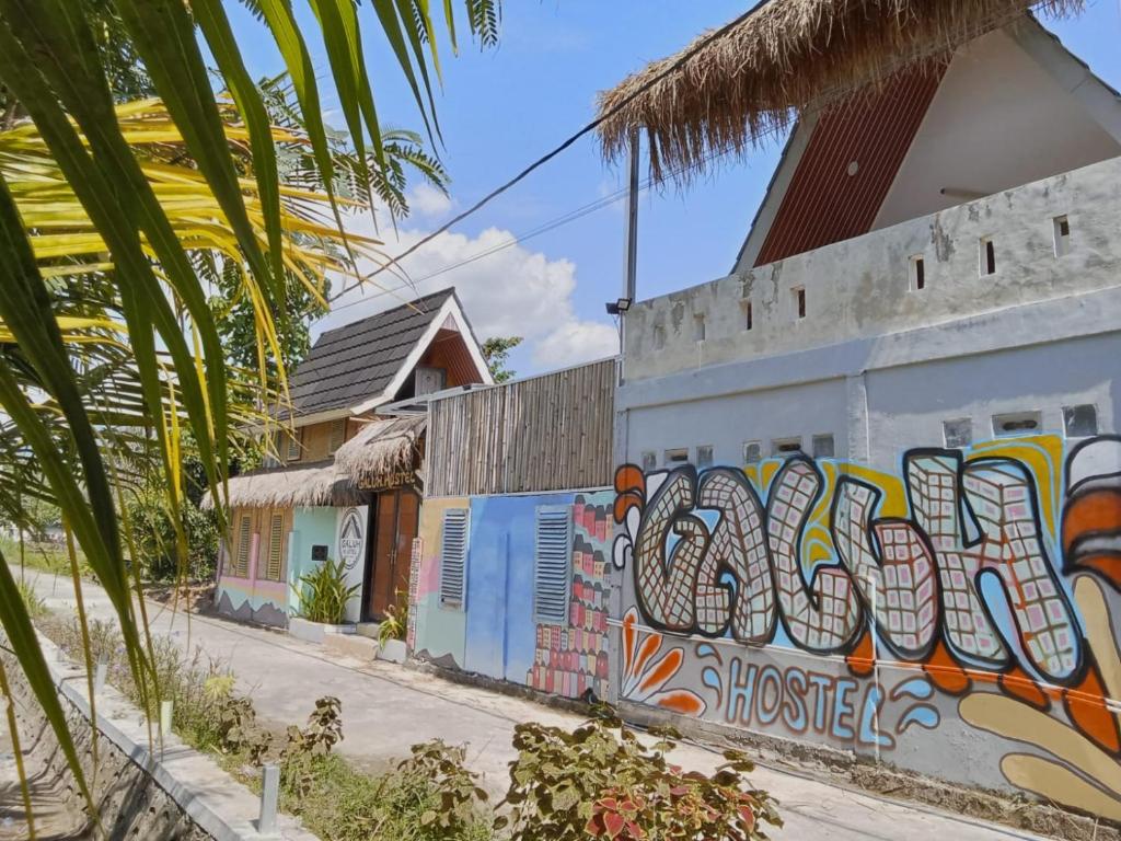 a building with graffiti on the side of it at Galuh Hostel Lombok in Pawenang