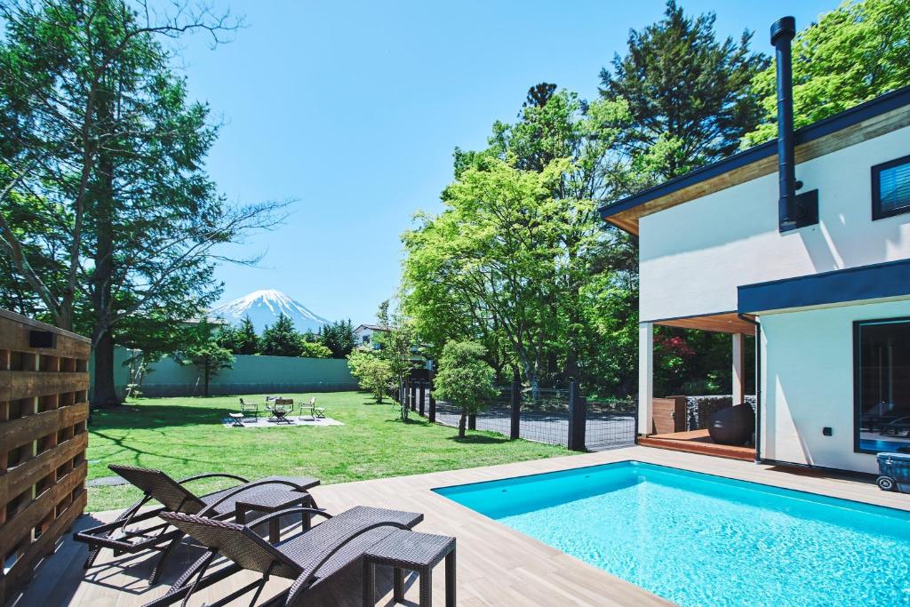 a backyard with a swimming pool and a house at Villa Saison Fuji ヴィラ セゾン フジ in Fujikawaguchiko