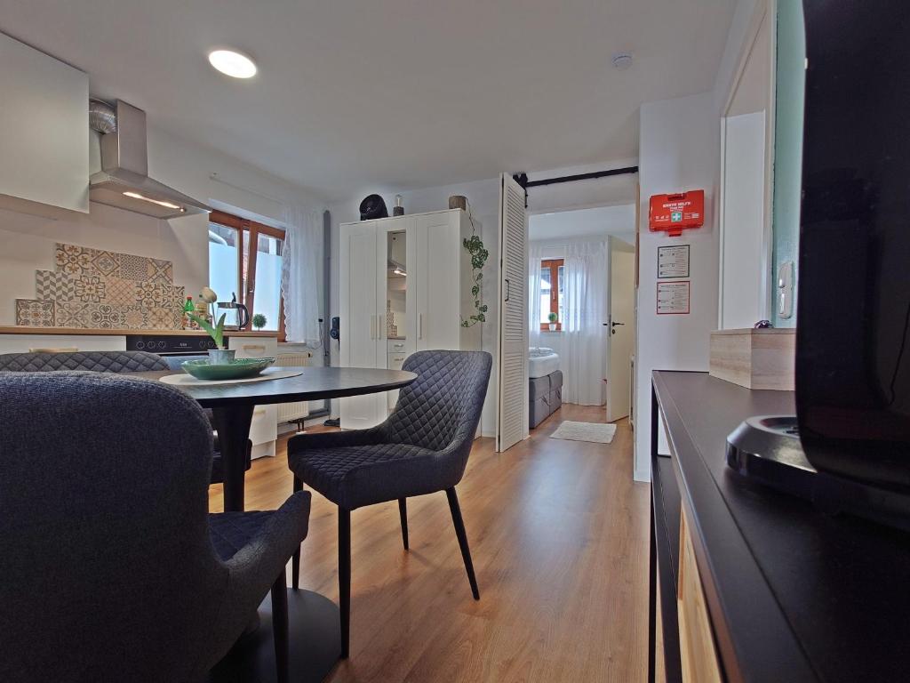 a kitchen and living room with a table and chairs at JIRVISTA-Homes, voll ausgestattete Wohnung im EG, kontaktloser Zutritt in Burghausen