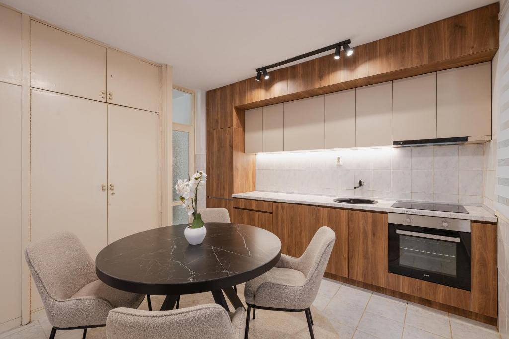 a kitchen with a black table and chairs and a counter at Mila in Herceg-Novi