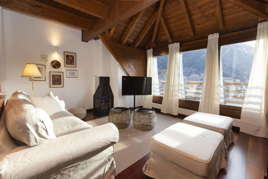 a living room with white furniture and a large window at Mirador de Sallent by BeValle in Sallent de Gállego