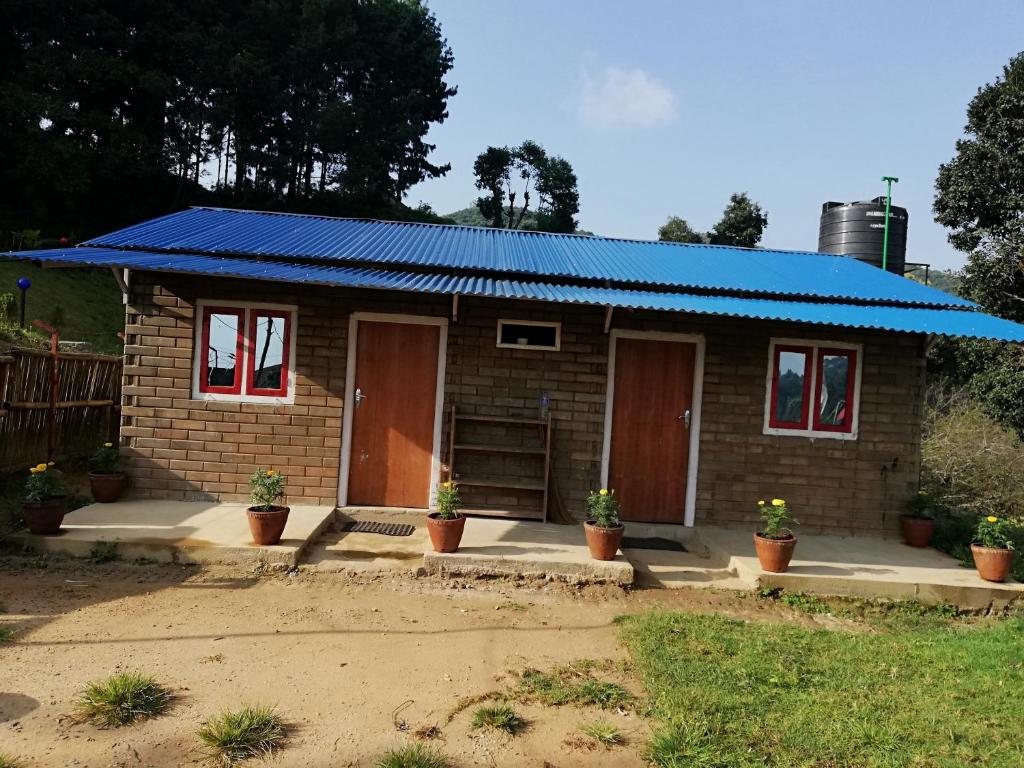 a small brick house with a blue roof at Syangbo Homestay in Nagarkot