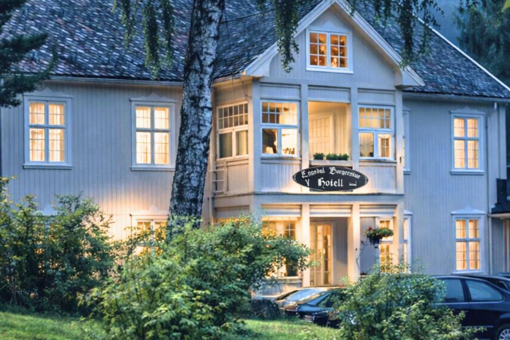 a large white house with cars parked in front of it at Eggedal Borgerstue in Eggedal