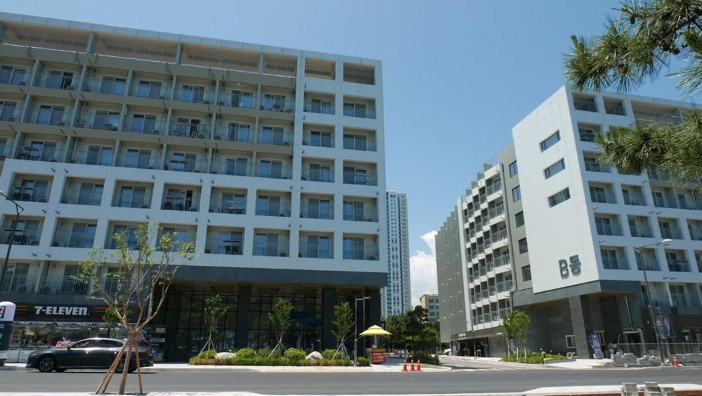 a large white building with a car parked in front of it at Sokcho Ocean Beach in Sokcho