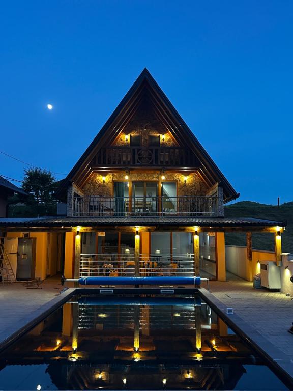 a house with a pool in front of it at night at Vikendica Vesic Tegare in Bratunac