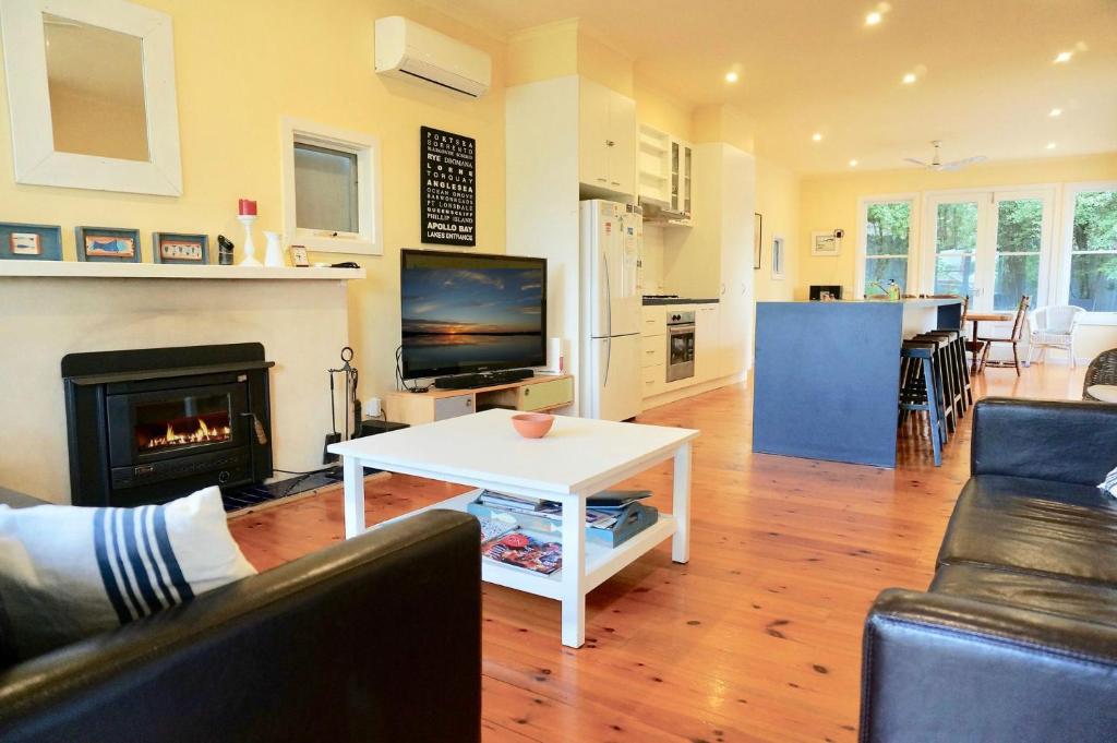 a living room with a table and a fireplace at Dinghy s Rest in Queenscliff
