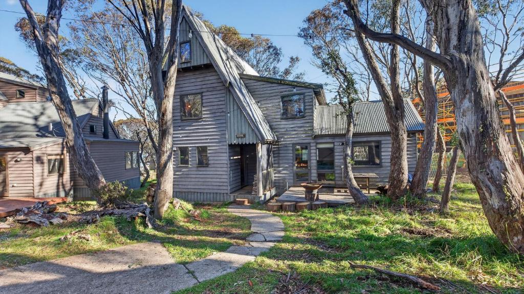 an old house with a porch and trees at Coho in Dinner Plain