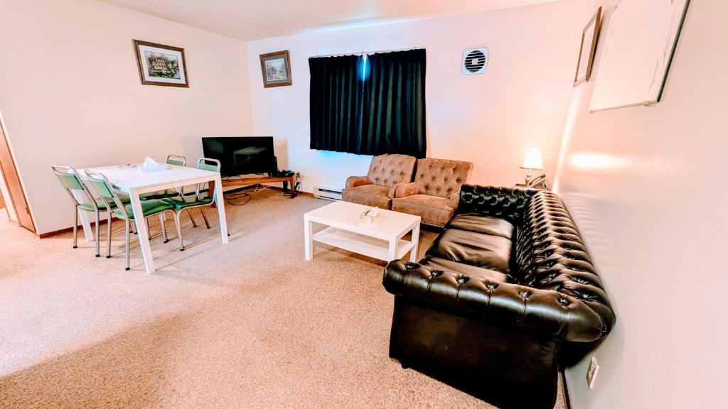 ein Wohnzimmer mit Ledersofa und einem Tisch in der Unterkunft The Voy in Schreiber