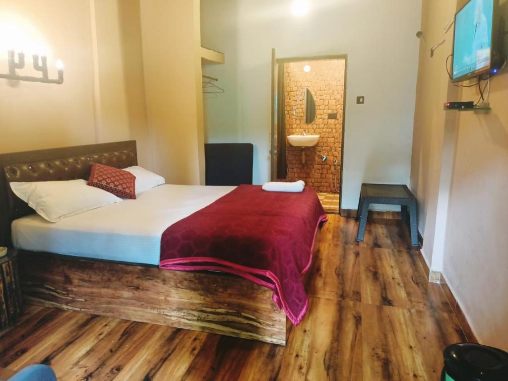 a bedroom with a bed with a red blanket on it at guest house carolina in Colva