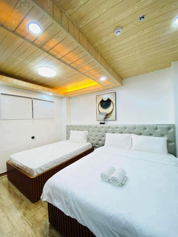 two beds with white sheets in a room at Nica's Palace Baguio in Baguio