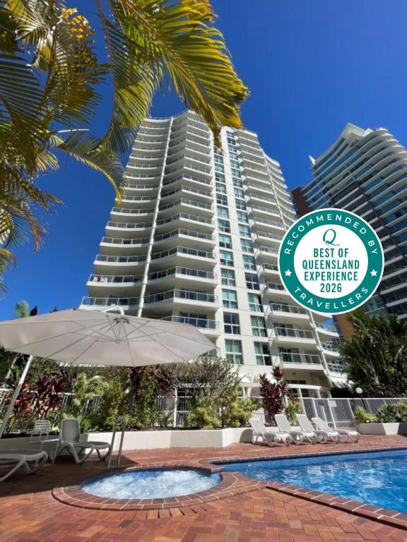 a large building with a swimming pool and a sign at The Crest Apartments - Main Beach in Gold Coast